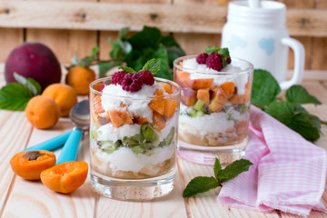 glass bowl with fresh fruits salad and berries on white wooden table