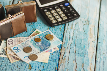 Fototapeta na wymiar Polish zloty with a wallet and calculator, wooden background