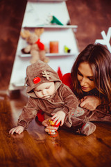 Mom playing with her son with toys on the warm clean floor