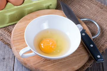 Beautiful picture of eggs in a white bowl with beaters near yolk