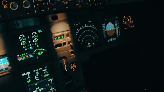 Close shot of modern aircraft cabin with buttons and knobs. Interior of Airbus A319 A320 A321. Panorama from pedestal to overhead panel trough centre panel and front window. Before takeoff and