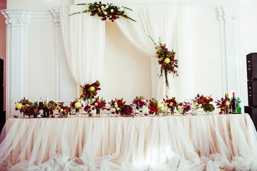 The vases with flowers stand on the wedding table