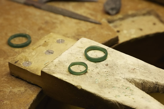 A workbench with three rings in a green material. 