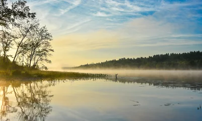 Foto op Canvas Brilliant and bright mid-summer sunrise on a lake.   Warm water and cooler air at daybreak creates misty fog patches.  Still water along a calm, quiet Ontario lakeside.  © valleyboi63