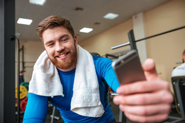 Attractive happy young sportsman make selfie by phone.