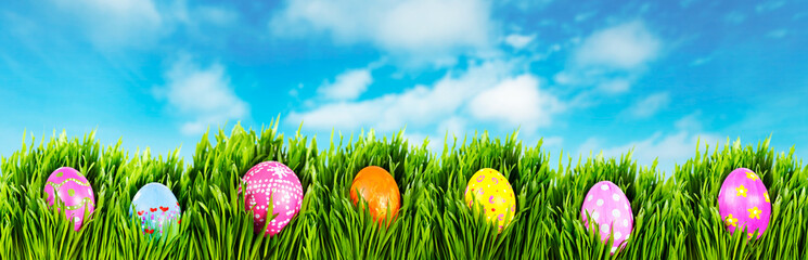 Hand painted easter eggs nestled in grass on a sunny Spring morning