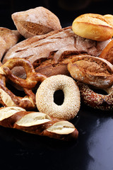 Different kinds of bread and bread rolls on board from above. Ki