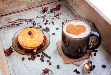 Coffee and roll on a wooden tray selective focus