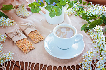Cup of coffee and grain small loafs on a table