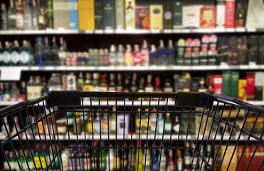 Abstract blurred image of alcohol store with trolley in department store. (Selective focused at...