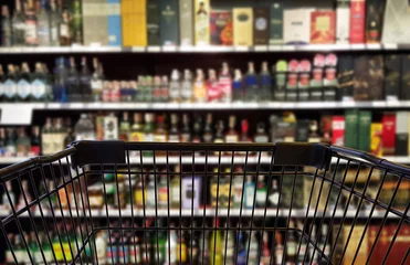 Foto op Plexiglas Abstract blurred image of alcohol store with trolley in department store. (Selective focused at shopping cart) © Direk Takmatcha