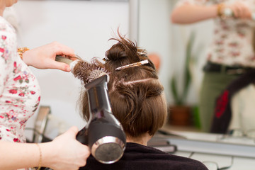 hairdresser drying female client's wet hair