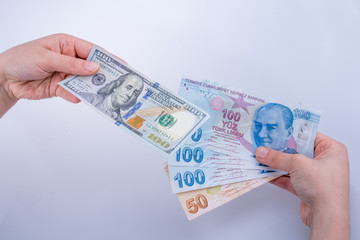 Hands holding American dollar banknotes and Turksh Lira banknote