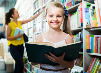 Cheerful child in school age shopping book