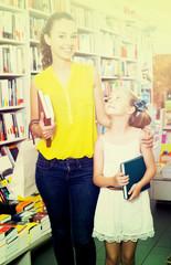 Woman with girl buying books