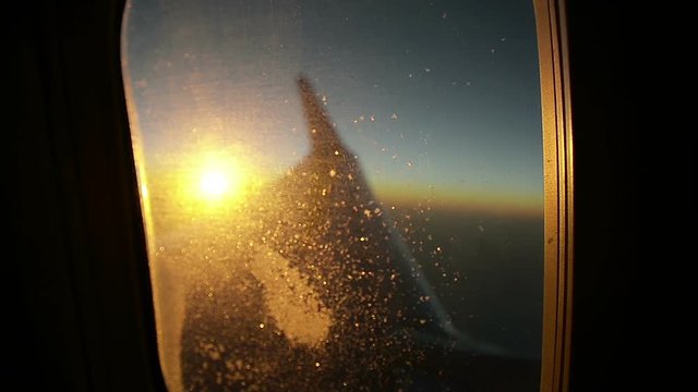 Airplane Window in the Rays of Sunlight at Sunset Focus on Window