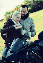 Fototapeta na wymiar Couple posing near motor bike