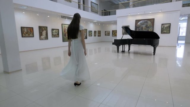 Musical pianist walk to piano in a concert hall. Steadycam shot. 4K.
