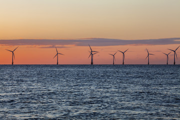 Offshore wind farm on the horizon at sunrise
