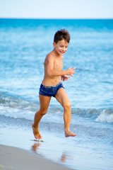 Six year old boy playing on beach
