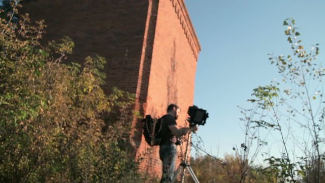 Man sets an old retro camera next to the chimney