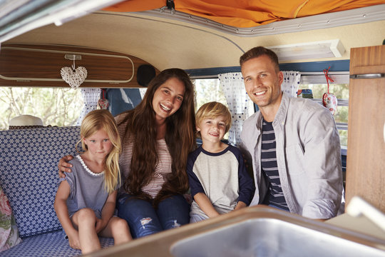 Smiling family portrait inside camper van