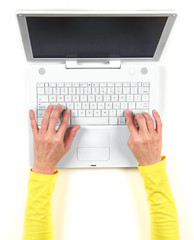 Hands in yellow jacket and white laptop