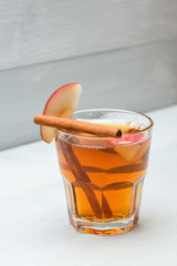 glass with juice, pieces of apple and cinnamon