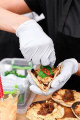 Obraz na płótnie Canvas Street vendor hands making taco outdoors