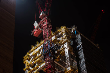 Budowa wieżowca w nocy przez Dźwig