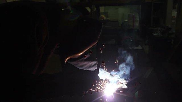 Man welding metal In factory