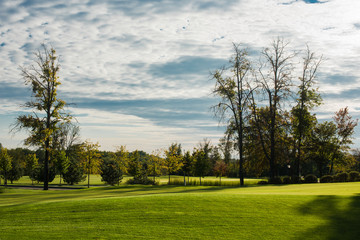 Golf course in the countryside. Beautiful green landscape. Golf course green in autumn colors.