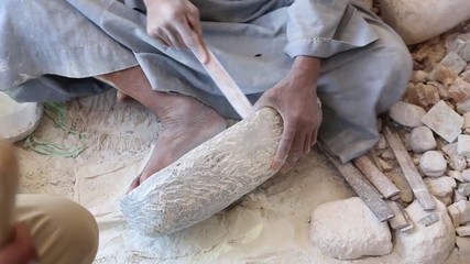 Close up of handcraft production of stone goods. Anonymous worker cutting something from stone material. Egypt traditions. Real time full hd video footage.