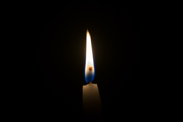 Fototapeta premium Single candle flame in the dark