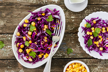 Red cabbage and sweet corn salad. Healthy vegetarian detox food. On wooden background, top view