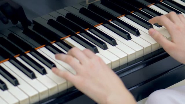 Woman musician hands playing a grand piano. 4K.