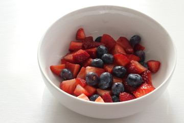 Image of Strawberries and blueberries in white bowl on white background
