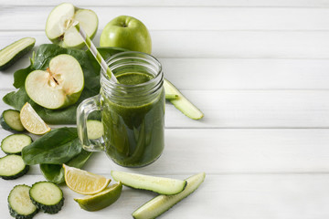 Natural detox green smoothie ingredients on white wood background