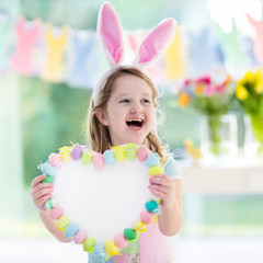 Little girl in bunny ears on Easter egg hunt