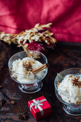 Delicious ice cream dessert in glass over black surface.