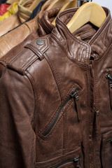 Different color leather jacket hanging on rack on white background