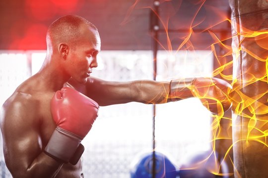 Side View Of Male Boxer Punching Bag