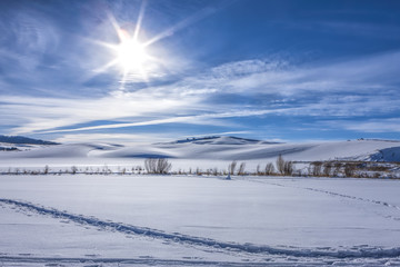 Fototapeta na wymiar Sun shines over snowy field in Moscow, Idaho.