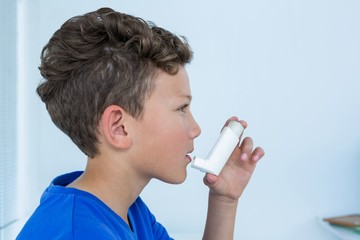 Boy using asthma pump