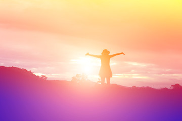 Silhouette of woman praying over beautiful sky background