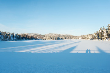 Fototapeta na wymiar Frozen lake in winter at sunset