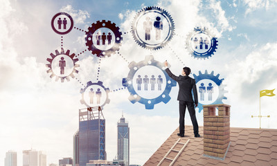 Businessman on house roof presenting teamwork and connection con
