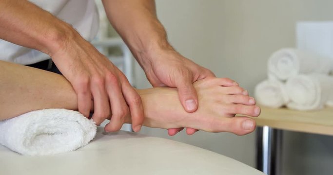Physiotherapist giving foot massage to a female patient in clinic 4k