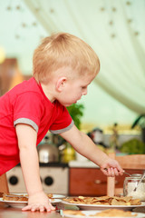 Little boy preparing pancakes for breaktfast
