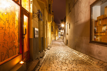 Old town narrow street at night. Bright stoned road and lantern.